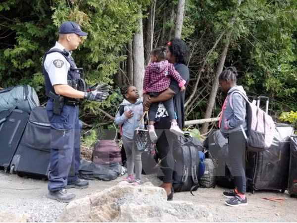 Cảnh sát Hoàng gia Canada kiểm tra một gia đình người tị nạn Haiti vào Canada từ Champlain, New York. (Nguồn: Reuters/TTXVN)