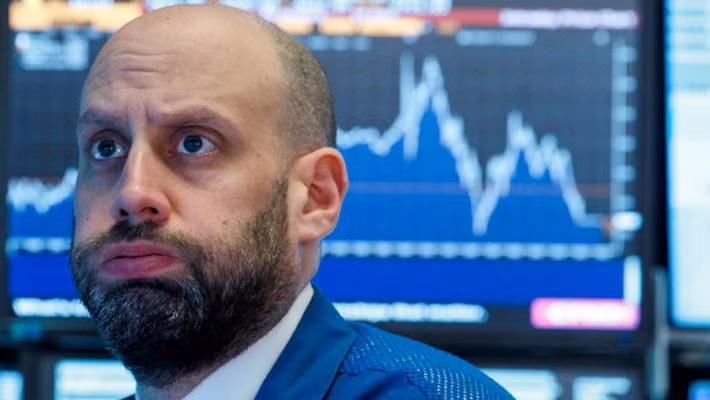 Phản ứng của một nhà giao dịch chứng khoán trên sàn NYSE ở New York trong phiên giao dịch ngày 22/3 - Ảnh: Reuters.