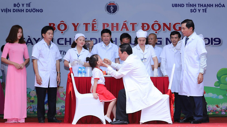 GS. TS. Nguyễn Viết Tiến, Thứ trưởng thường trực Bộ Y tế cùng các đại biểu khách mời cho các em học sinh uống vitamin A