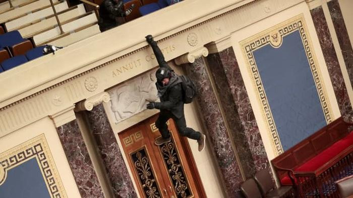 Một người biểu tình đu trên ban công tại khu vực làm việc của Thượng viện - Ảnh: Getty.