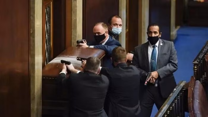 Cảnh sát mặc thường phục chặn cửa để người biểu tình không vào được phòng họp của Hạ viện - Ảnh: AP.