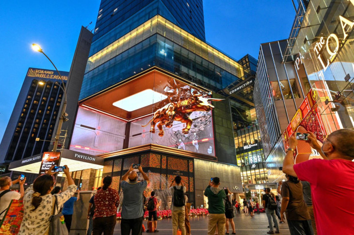 Người dân chụp ảnh màn hình 3D bên ngoài một trung tâm mua sắm tại Kuala Lumpur, Malaysia ngày 11/2 - Ảnh: Xinhua/Getty Images Người dân chụp ảnh màn hình 3D bên ngoài một trung tâm mua sắm tại Kuala Lumpur, Malaysia ngày 11/2 - Ảnh: Xinhua/Getty Images