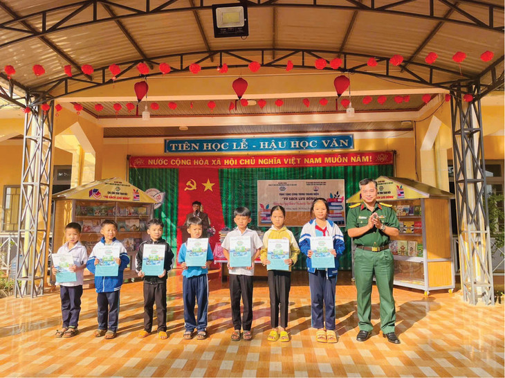 Thượng tá Trần Duy Trinh trao học bổng cho các em học sinh có hoàn cảnh khó khăn, động viên các em phấn đấu vượt mọi khó khăn, học tập chăm chỉ, đạt nhiều thành tích tốt