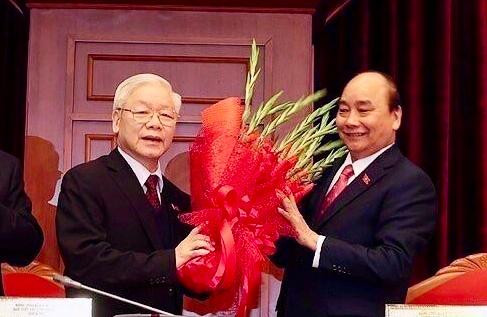 Thay mặt Bộ Chính trị khóa XIII, Thủ tướng Chính phủ Nguyễn Xuân Phúc tặng hoa chúc mừng đồng chí Nguyễn Phú Trọng được tín nhiệm bầu làm Tổng Bí thư Ban Chấp hành Trung ương Đảng Cộng sản Việt Nam khóa XIII.