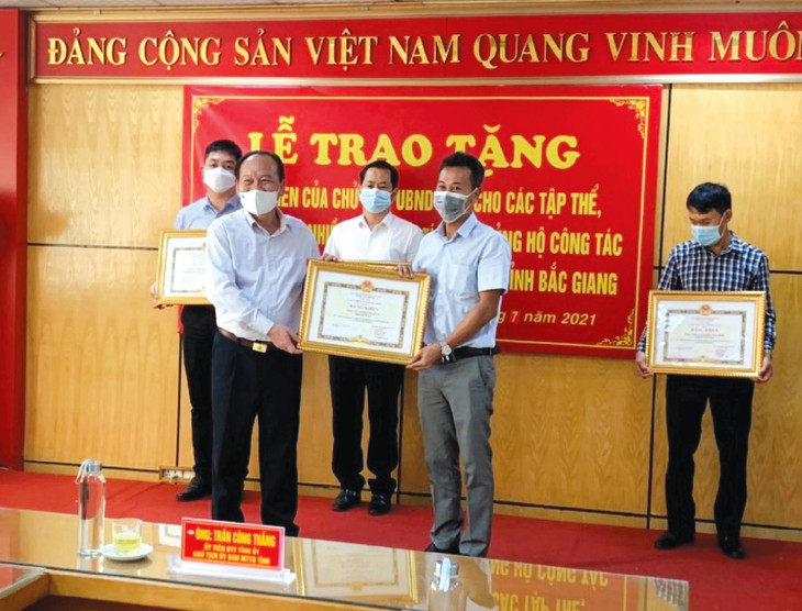 Ông Trần Công Thắng (bên trái) - Chủ tịch Ủy ban Mặt trận Tổ quốc tỉnh Bắc Giang thay mặt Chủ tịch UBND tỉnh Bắc Giang tặng Bằng khen cho đại diện Công ty CP Hà Đô 23