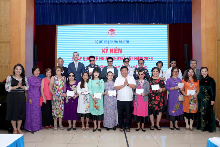 Bộ trưởng Nguyễn Chí Dũng cùng đại diện một số tổ chức quốc tế động viên và chụp ảnh lưu niệm với người khiếm thị trong Dàn hợp ca Hy vọng, do Giáo sư Tôn Thất Triêm dẫn dắt. Ảnh: Đức Trung Bộ trưởng Nguyễn Chí Dũng cùng đại diện một số tổ chức quốc tế động viên và chụp ảnh lưu niệm với người khiếm thị trong Dàn hợp ca Hy vọng, do Giáo sư Tôn Thất Triêm dẫn dắt. Ảnh: Đức Trung