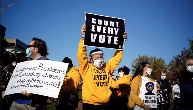 Cử tri giơ biển yêu cầu kiểm đếm tất cả phiếu bầu một cách công bằng tại Philadelphia, bang Pennsylvania ngày 4/11 - Ảnh: Reuters.