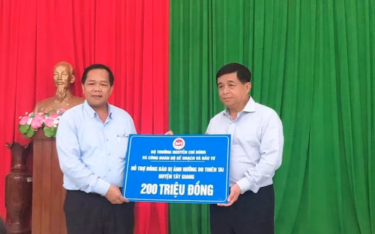 Bộ trưởng Nguyễn Chí Dũng trao phần quà của Bộ trưởng và công đoàn Bộ Kế hoạch và Đầu tư hỗ trợ nhân dân huyện Tây Giang