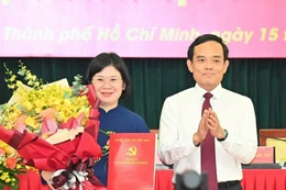 Bí thư Trung ương Đảng, Bí thư Thành ủy Thành phố Hồ Chí Minh Trần Lưu Quang trao quyết định cho đồng chí Văn Thị Bạch Tuyết. (Ảnh: TTXVN phát)