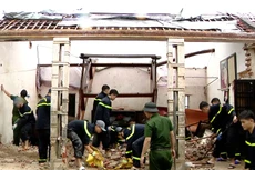 Các chiến sĩ Công an đang hỗ trợ người dân khắc phục hậu quả do Bão số 10 gây ra