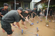 Các chiến sĩ Công an hỗ trợ nhân dân Khánh Hòa dọn dẹp vệ sinh sau đợt mưa lũ