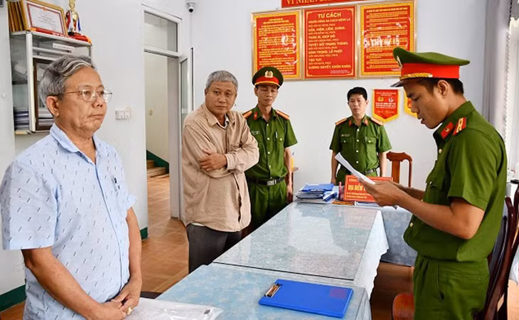 Cảnh sát đọc lệnh khởi tố và lệnh bắt ông Thái Minh Hoàng (bên trái) và Nguyễn Đình Tấn (ở giữa)