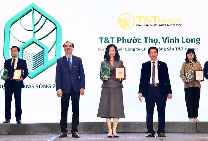 Bà Trần Thị Minh Thúy – Tổng Giám đốc T&amp;T Homes (chính giữa) lên nhận giải Dự án đáng sống 2024 cho dự án Khu dân cư Phước Thọ (Vĩnh Long).