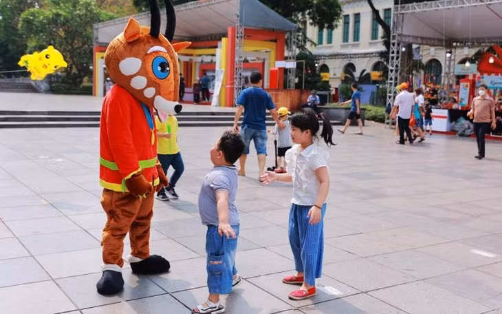 Du khách nhí tương tác với chú sao la-linh vật của SEA Games 31 tại Lễ hội quà tặng du lịch Hà Nội 2022.