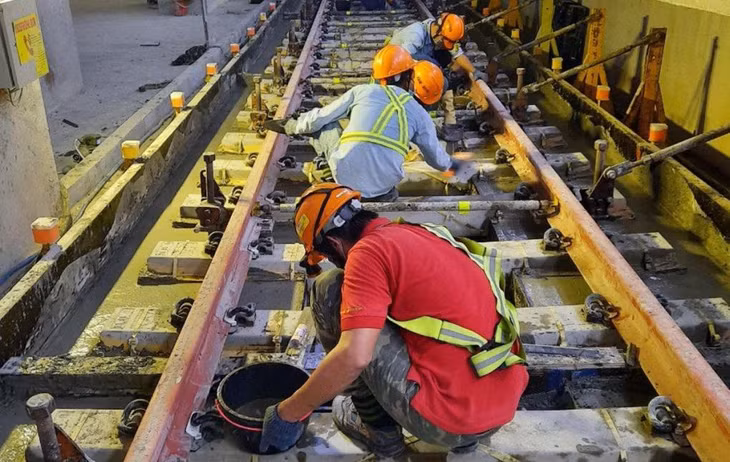 Công nhân thi công lắp đặt đoạn ray cuối cùng của Metro Số 1, ngày 9/11