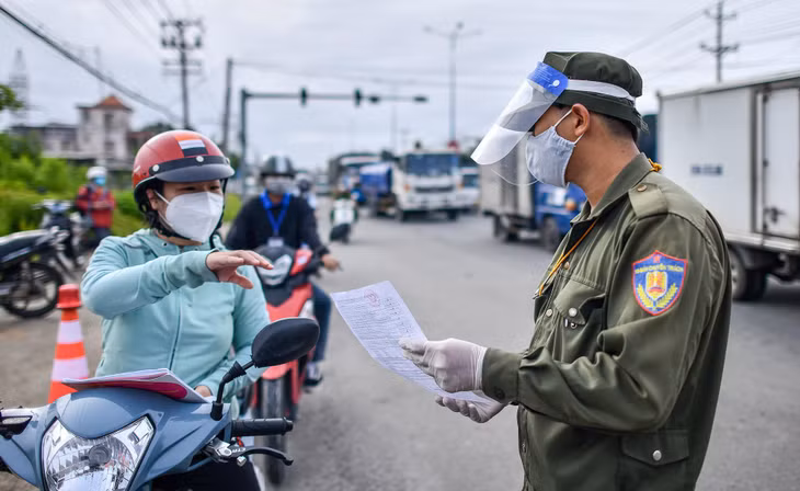 Chị Lan xuất trình giấy tờ khi qua chốt kiểm soát tại quốc lộ 13, đoạn giáp ranh giữa TP Thủ Dầu Một và thị xã Thuận An (Bình Dương). "Tôi có nghe thành phố thông báo điều kiện để di chuyển liên phường. Tôi đã tiêm 2 mũi vaccine và cũng có phiếu xác nhận âm tính", người phụ nữ nói.