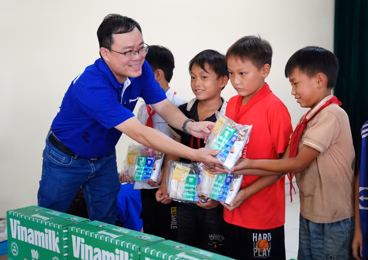 Ông Tạ Xuân Tuấn - Giám đốc Kinh doanh Miền Bắc của Vinamilk, trao phần quà cho các bé ở xóm Trung Sơn, xã Quang Sơn, huyện Đồng Hỷ (tỉnh Thái Nguyên) gồm sữa, bánh