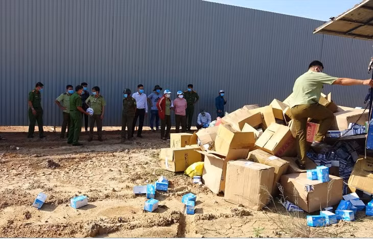 Hội đồng tiêu hủy thuốc lá ngoại và khẩu trang y tế giám sát việc tiêu hủy. Ảnh: QLTT