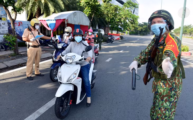 Trung sĩ Nguyễn Thanh Tùng thuộc Sư Đoàn Bộ binh 5 hướng dẫn người dân lưu thông sau khi đã kiểm tra đầy đủ giấy tờ Trung sĩ Nguyễn Thanh Tùng thuộc Sư Đoàn Bộ binh 5 hướng dẫn người dân lưu thông sau khi đã kiểm tra đầy đủ giấy tờ