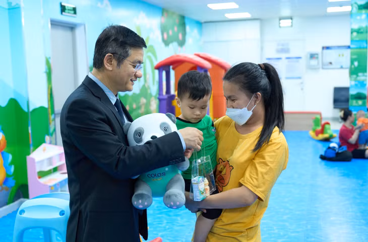 Ông Nguyễn Quang Trí – Giám đốc Điều hành Vinamilk, tặng quà cho các gia đình, các bé đến tiêm ngừa tại Trung tâm VNVC trong ngày kí kết hợp tác. Ảnh: Vi Nam