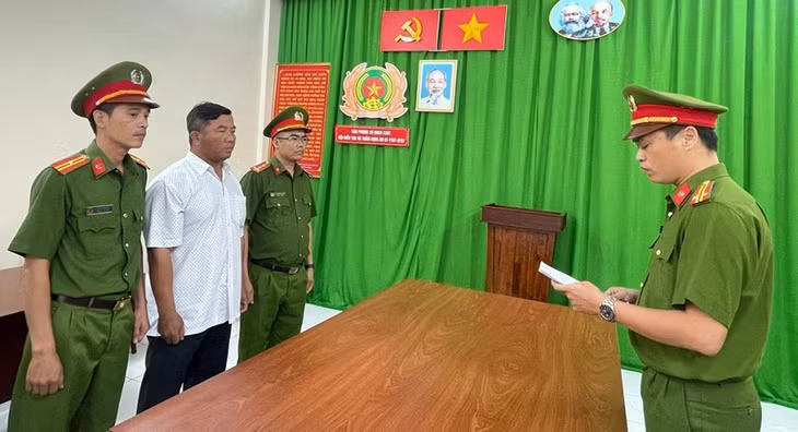 Ông Phạm Hoài Hà (áo trắng) nghe cảnh sát đọc quyết định tạm giam