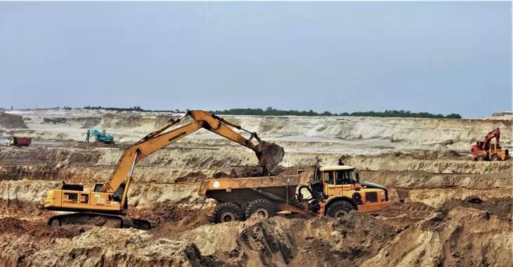 Giai đoạn 2008 - 2011, chủ đầu tư đã cho bóc đất tầng phủ được khoảng 12,7 triệu m3, độ sâu -34 m so với mực nước biển, thu hồi khoảng 3.000 tấn quặng. Tuy nhiên, đến tháng 11/2011, Chính phủ phải cho tạm dừng Dự án để thẩm định lại thiết kế kỹ thuật và tái cơ cấu cổ đông do vướng mắc về huy động và góp vốn, dẫn đến hệ lụy như: Chậm tiến độ giải phóng mặt bằng, thiếu tiền thanh toán cho nhà thầu tư vấn lập thiết kế kỹ thuật và xây dựng khu tái định cư.