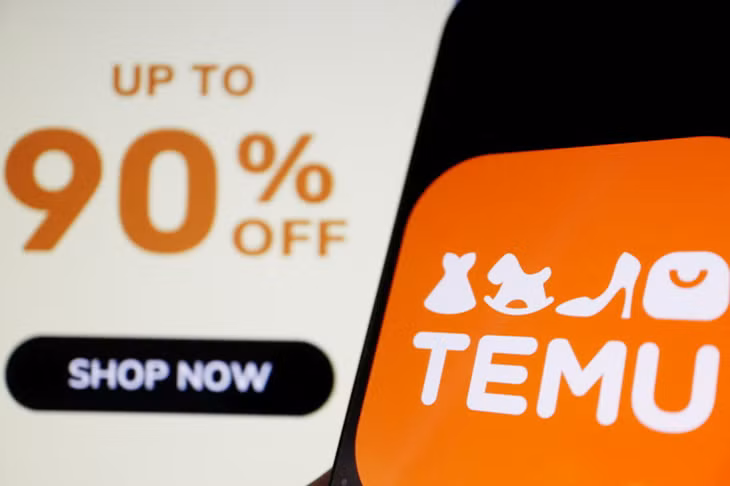 Logo của Temu trên điện thoại di động với hậu cảnh là trang web của công ty Logo của Temu trên điện thoại di động với hậu cảnh là trang web của công ty