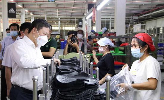 Phó Chủ tịch UBND Thành phố Hồ Chí Minh Dương Anh Đức thăm hỏi công nhân tại các chuyền sản xuất của Công ty Trách nhiệm hữu hạn Pouyuen Việt Nam ở quận Bình Tân. Ảnh: TTXVN