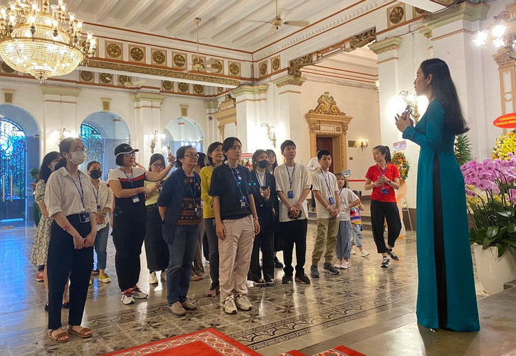 Du khách vào tham quan lắng nghe thuyết minh về nguồn gốc toà nhà HĐND - UBND TP.HCM. Ảnh minh họa