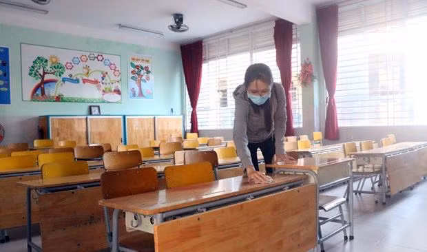 Vệ sinh bàn ghế, lớp học chuẩn bị cho học sinh quay trở lại trường. Nguồn: TTXVN