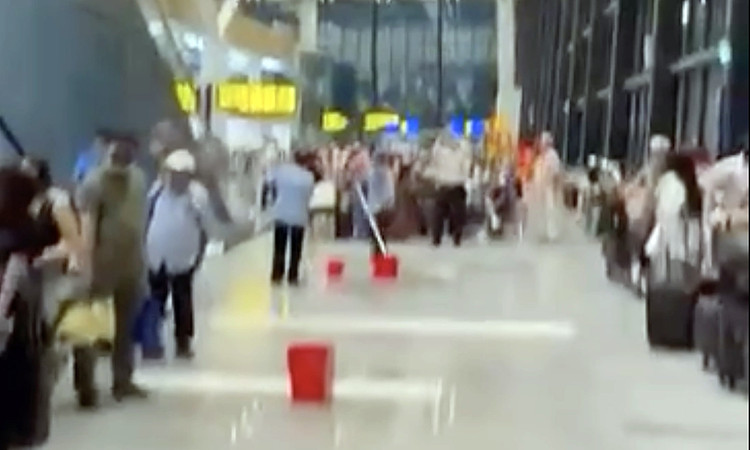 Nhân viên nhà ga dọn dẹp, dùng xô đựng nước trong cơn mưa lớn chiều 7/5. Ảnh: Cắt từ video người dân 