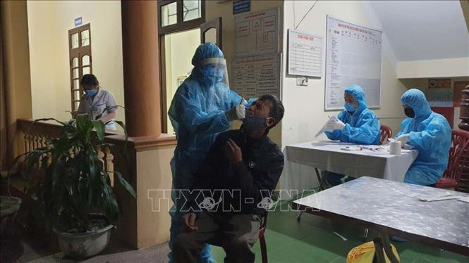 Lấy mẫu xét nghiệm sàng lọc người mắc COVID-19. Ảnh: TTXVN