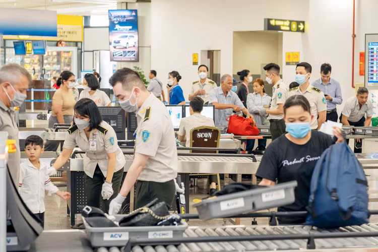 Nhân viên an ninh tại Cảng hàng không quốc tế Nội Bài kiểm tra hành khách qua cửa soi chiếu