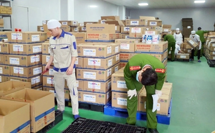 Công an kiểm tra sản phẩm sữa giả. Ảnh: CAND