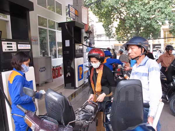 Nhân viên Petrolimex đang bán xăng cho khách hàng. (Ảnh: Đức Duy/Vietnam+)