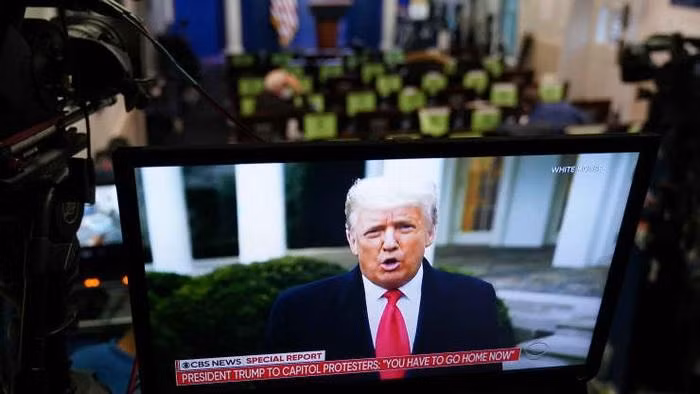 Một bản tin truyền hình đưa tin về đoạn video mà ông Trump đăng lên mạng Twitter kêu gọi người biểu tình đi về nhà - Ảnh: Getty.