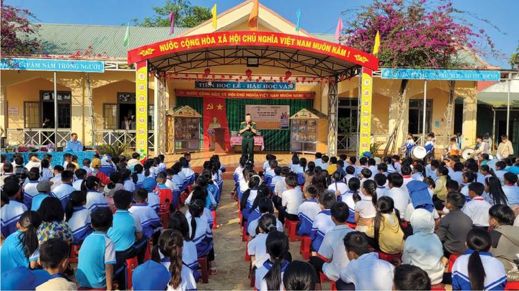 Thượng tá Trần Duy Trinh - Chủ nhiệm Chính trị Công ty TECAPRO trò chuyện với học sinh Trường Tiểu học Lê Văn Tám, xã Đắk N’Drung, huyện Đắk Song, tỉnh Đắk Nông