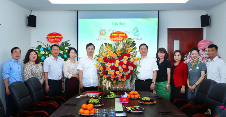 Thứ trưởng Bộ Kế hoạch và Đầu tư Trần Duy Đông trao lẵng hoa của Bộ trưởng Nguyễn Chí Dũng chúc mừng Báo Đấu thầu. Ảnh: Lê Tiên