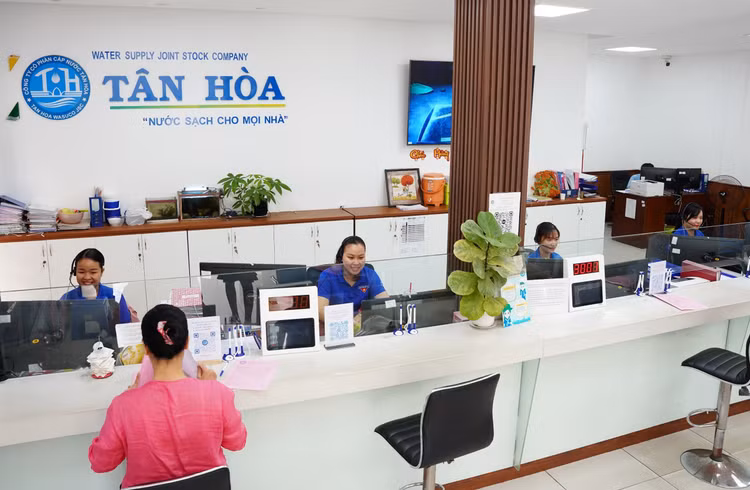 Nhân viên Công ty CP Cấp nước Tân Hòa hỗ trợ khách hàng đến giao dịch