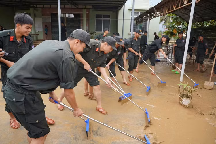 Các chiến sĩ Công an hỗ trợ nhân dân Khánh Hòa dọn dẹp vệ sinh sau đợt mưa lũ