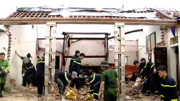 Các chiến sĩ Công an đang hỗ trợ người dân khắc phục hậu quả do Bão số 10 gây ra