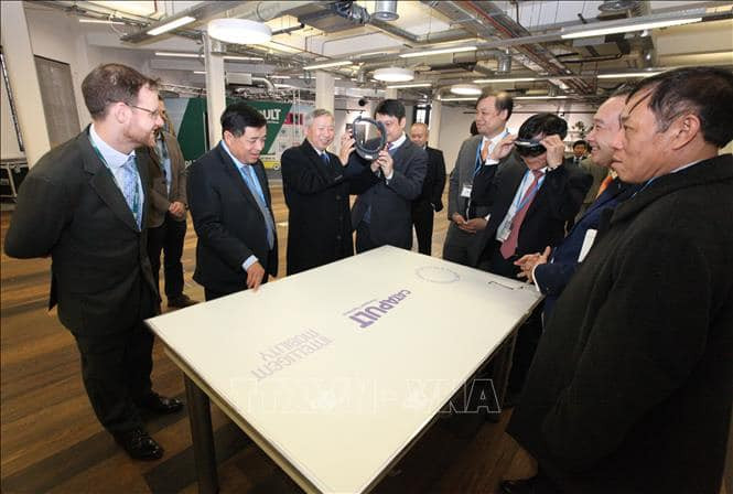 Bộ trưởng Nguyễn Chí Dũng và đoàn công tác xem giới thiệu về công nghệ thực tế ảo trong quy hoạch đô thị tại Trung tâm Đổi mới sáng tạo của Anh (NET). Ảnh: TTXVN