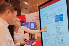 Nhân viên EVNSPC hướng dẫn khách hàng trải nghiệm thực tế các tính năng nổi bật của App CSKH EVNSPC trên màn hình tương tác