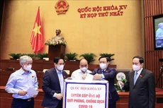 Chủ tịch nước Nguyễn Xuân Phúc, Thủ tướng Phạm Minh Chính, Chủ tịch Quốc hội Vương Đình Huệ và các đại biểu Quốc hội quyên góp ủng hộ Quỹ phòng chống dịch Covid-19. Ảnh: TTXVN