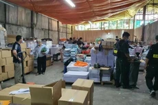 Lực lượng chức năng khám xét địa điểm trong đường dây sản xuất sách giáo khoa giả. Ảnh: ANTĐ