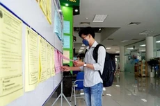Người lao động tìm hiểu công việc tại phiên giao dịch việc làm. Ảnh: TTXVN