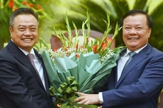 Tân Chủ tịch UBND TP. Hà Nội Trần Sỹ Thanh (trái) nhận hoa chúc mừng từ Bí thư Thành ủy Hà Nội Đinh Tiến Dũng. Ảnh: Giang Huy