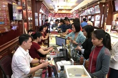 Khách hàng giao dịch vàng miếng. Ảnh: Vietnam+