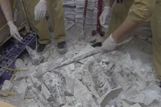 Lực lượng chức năng phải dùng dụng cụ chuyên dụng để đập phá thạch cao, lấy ra những khúc sừng tê giác. Ảnh: H.Q.