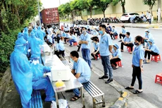 Sự đồng lòng của nhân dân là chìa khóa mở cánh cửa lớn để chúng ta thoát ra khỏi đại dịch và trở về cuộc sống bình thường. Ảnh: Huấn Anh